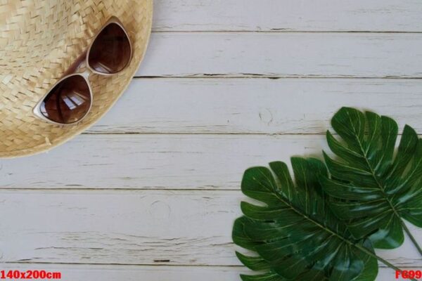 straw hat, sunglasses and green leaves. summer concept