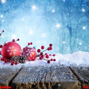 red christmas ornament on snowy table with snowfall on backgroun