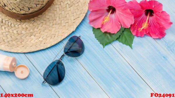 hat, sunglasses, sunblock and chinese rose flower on a blue wooden table.