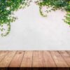 empty wood table with ivy leaves on cement wall background.