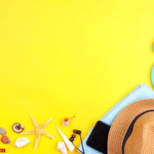 sun glasses, sun screen, headphones, smartphone, towel, slippers. flatlay beach vacation on a yellow background.