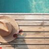 top view of poolside, sun hat and sunglasses on wooden floor