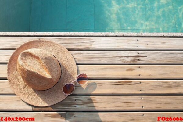 top view of poolside, sun hat and sunglasses on wooden floor