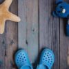 moscow, russia 05.28.2018: baby beach slippers, starfish, teddy bear on wooden background