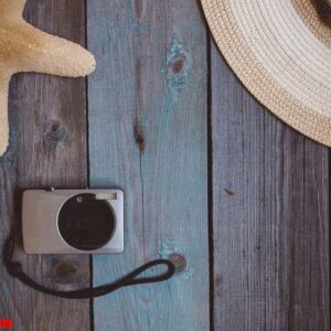 a hat, camera, a starfish, on the wooden background