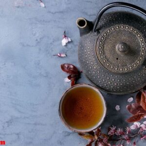 teapot and cup of tea with blossom branch