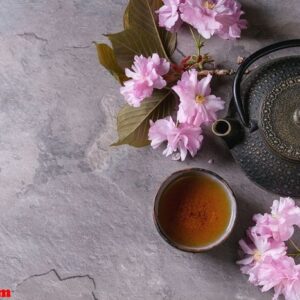 teapot and cup of tea with blossom branch