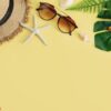 travel accessories items on yellow background, summer vacation concept