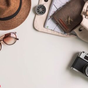 retro camera with travel accessories and items on white background with copy space, travel concept