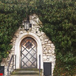 the wooden door in stone wall of the old medieval castle