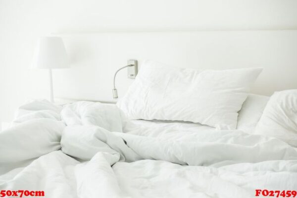 white pillow on rumpled bed