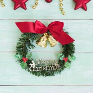 christmas wreath with golden bells and red ribbon bow vertical