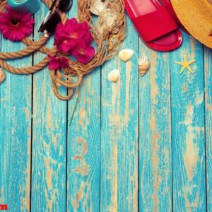 bright composition of female beach accessories on blue wooden background