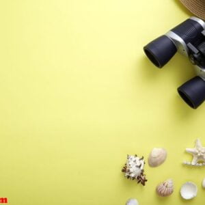 flat lay yellow suitcase with traveler accessories on yellow background