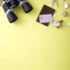 flat lay yellow suitcase with traveler accessories on yellow background