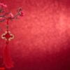 chinese new year's decoration flowers plum blossoming with chinese knot on red bokeh background