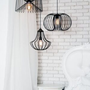 black lamps in light bedroom interior. three modern black lamps hanging