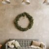 gray sofa with pillows and christmas wreath on the wall in the living room