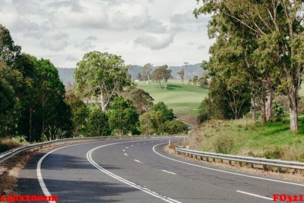 beautiful australian road crossing a green landscape.