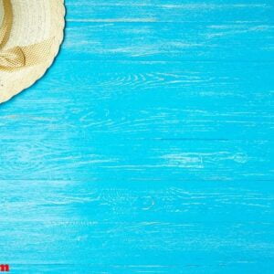 frame elegant female straw hat on blue wooden background, copyspace for text, summer vacation.