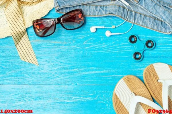 frame elegant female straw hat slippers jeans sunglasses on blue wooden background, copyspace for text, summer vacation.