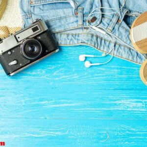 frame elegant female straw hat slippers jeans camera on blue wooden background, copyspace for text, summer vacation.