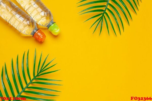 transparent liquid bottle with tropical palm leaves, top view