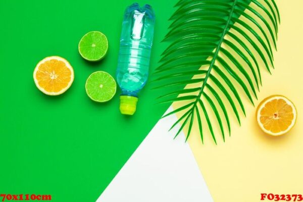 tropic leaves and bottle l water on yellow background. detox fruit infused water.