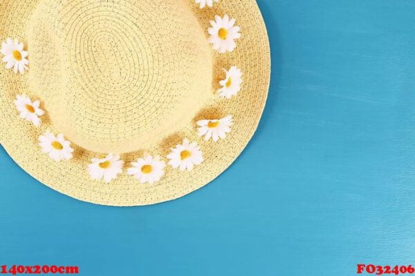 straw hat with camomile on a blue background. top view. summer background. flat lay.