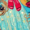 bright composition of female beach accessories on blue wooden background