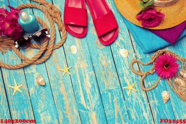 bright composition of female beach accessories on blue wooden background