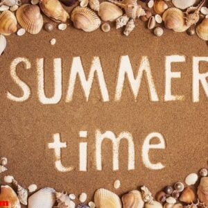 summer time is written on the sand in frame of sea shells. trave