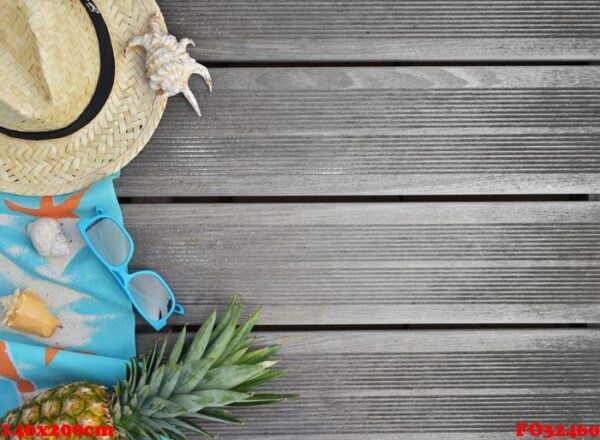 top view on straw hat, beach towel, sunglasses and pineapple on wooden terrace