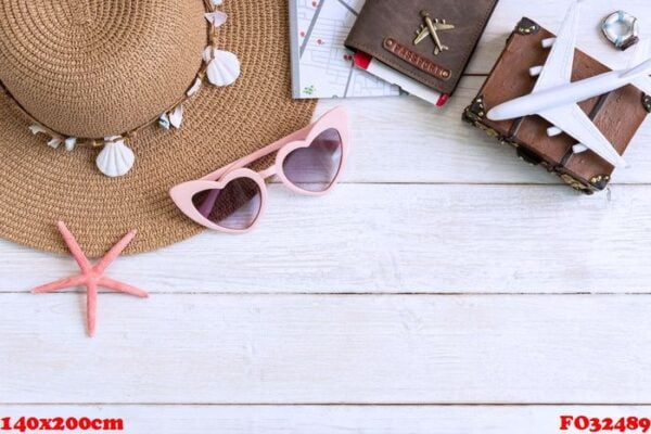 beach hat with travel items on white wooden background, summer vacation concept