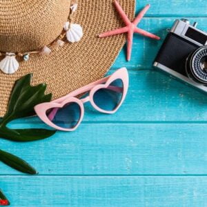 travel accessories items on wooden background, summer vacation concept