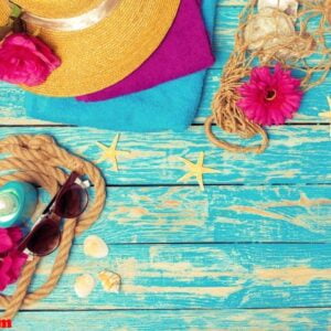 bright composition of female beach accessories on blue wooden background