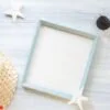 top view of summer blue picture frame with sunglasses and seashe
