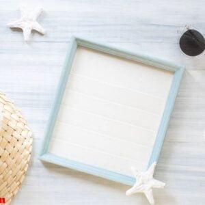 top view of summer blue picture frame with sunglasses and seashe