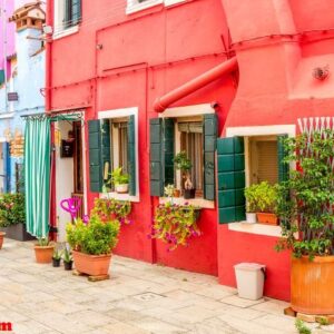 beautiful colorful red small house with plants in burano island near venice, italy