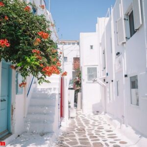 the narrow streets of the island with blue balconies, stairs and flowers.