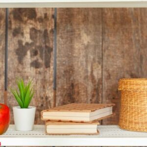 stylish white bookshelf against grunge wooden wall