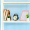 white metal rack with books against blue background