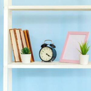 white metal rack with books against blue background