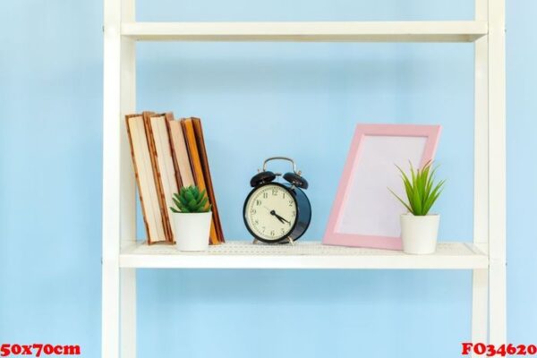 white metal rack with books against blue background