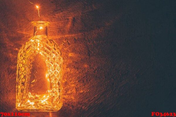 lights garland in a glass bottle on a dark background