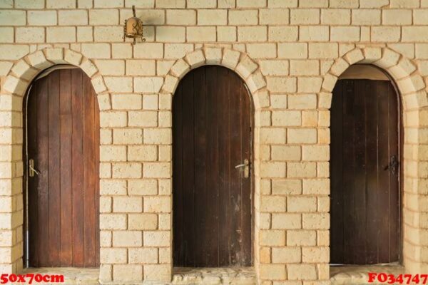 close up of three wooden doors and white brick wall