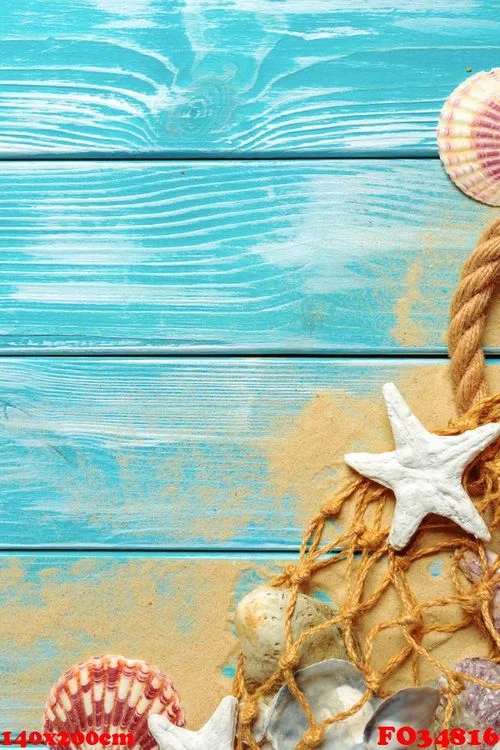 sea rope with many different sea shells on the sea sand on a blue wooden background. top view