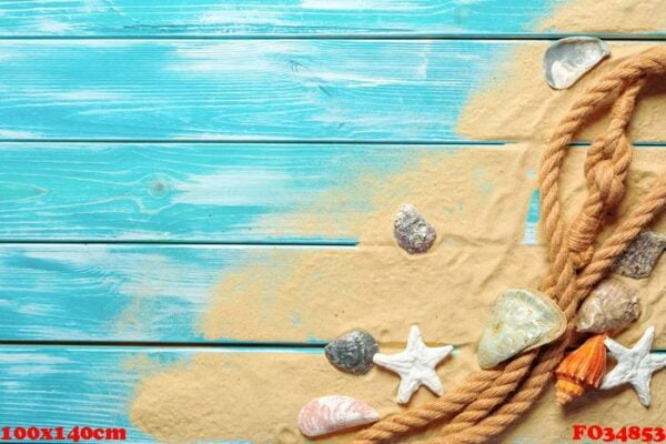 sea rope with many different sea shells on the sea sand on a blue wooden background. top view