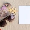 holiday beach concept with shells, seastars and an blank postcard