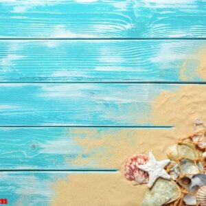 sea rope with many different sea shells on the sea sand on a blue wooden background. top view